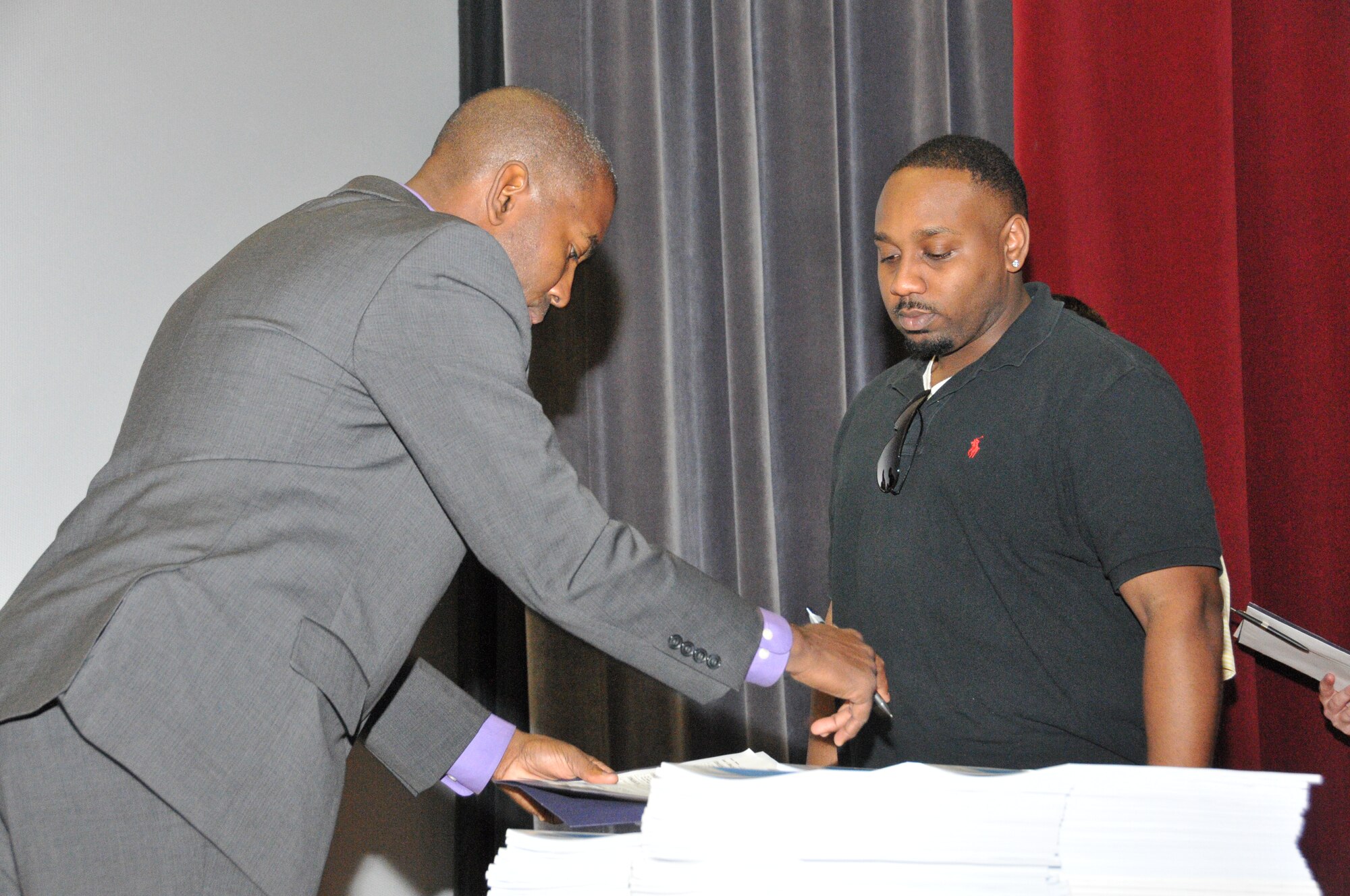 Travis Rambert (left), Veterans Affairs benefits advisor, signs Garrett Harper's check list during the Individual Ready Reserve muster May 17, 2014, at Dover Air Force Base, Del. Harper, an Air Force IRR member, is one of about 170 others who attended the muster, which afforded them the opportunity to update their personnel and medical information with the Air Reserve Personnel Center and hear the latest benefits available to them through Veterans Affairs. (U.S. Air Force photo/Senior Airman Joe Yanik)