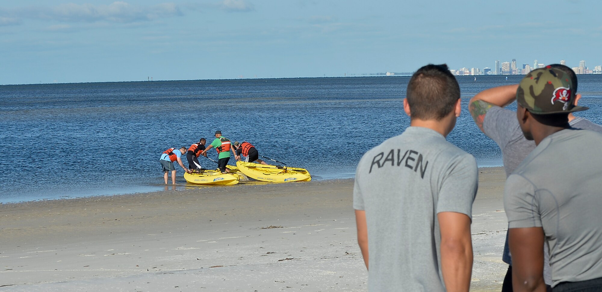 Members from the 6th Security Forces Squadron watch as fellow defenders participate in a kayak race during a defenders challenge, May 16, 2014 at MacDill Air Force Base, Fla. The race kicked off the challenge and was followed by an ammo can lift, dissemble and reassemble of a rifle, a ruck march and an active shooter event.(U.S. Air Force photo by Senior Airman Jenay Randolph/Released)