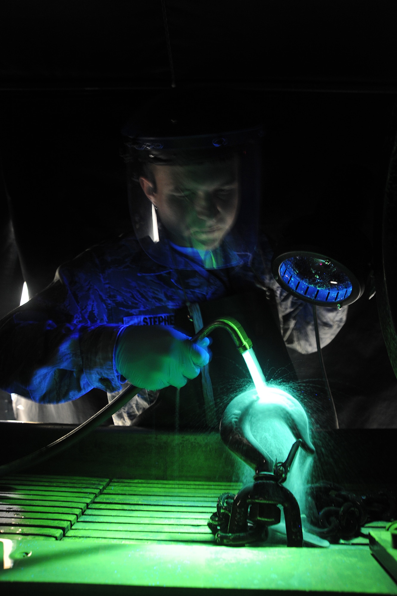 Senior Airman Chase Stephans, 509th Maintenance Squadron non-destructive inspection technician, uses a black light to inspect an aircraft part at Whiteman Air Force Base, Mo., May 8, 2014. The black light causes particles normally unseen by the human eye to become florescent.(U.S. Air Force photo by Senior Airman Bryan Crane/Released)