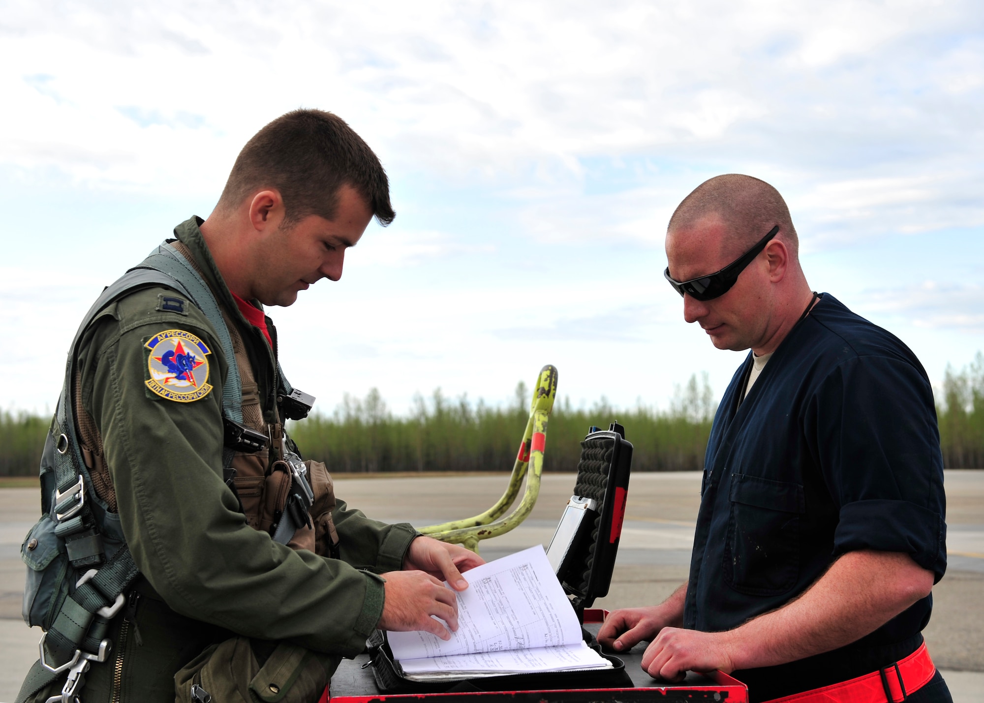 U.S. Air Force Capt. A.J. Roper, 18th Aggressor Squadron pilot, reviews a pre-flight checklist with Staff Sgt. Joseph Misiewicz, 354th Aircraft Maintenance Squadron crew chief, May 16, 2014, Eielson Air Force Base, Alaska. Aggressor pilots and maintainers work together during RED FLAG-Alaska 14-1 to ensure safe flights. (U.S. Air Force photo by Senior Airman Ashley Nicole Taylor/Released)