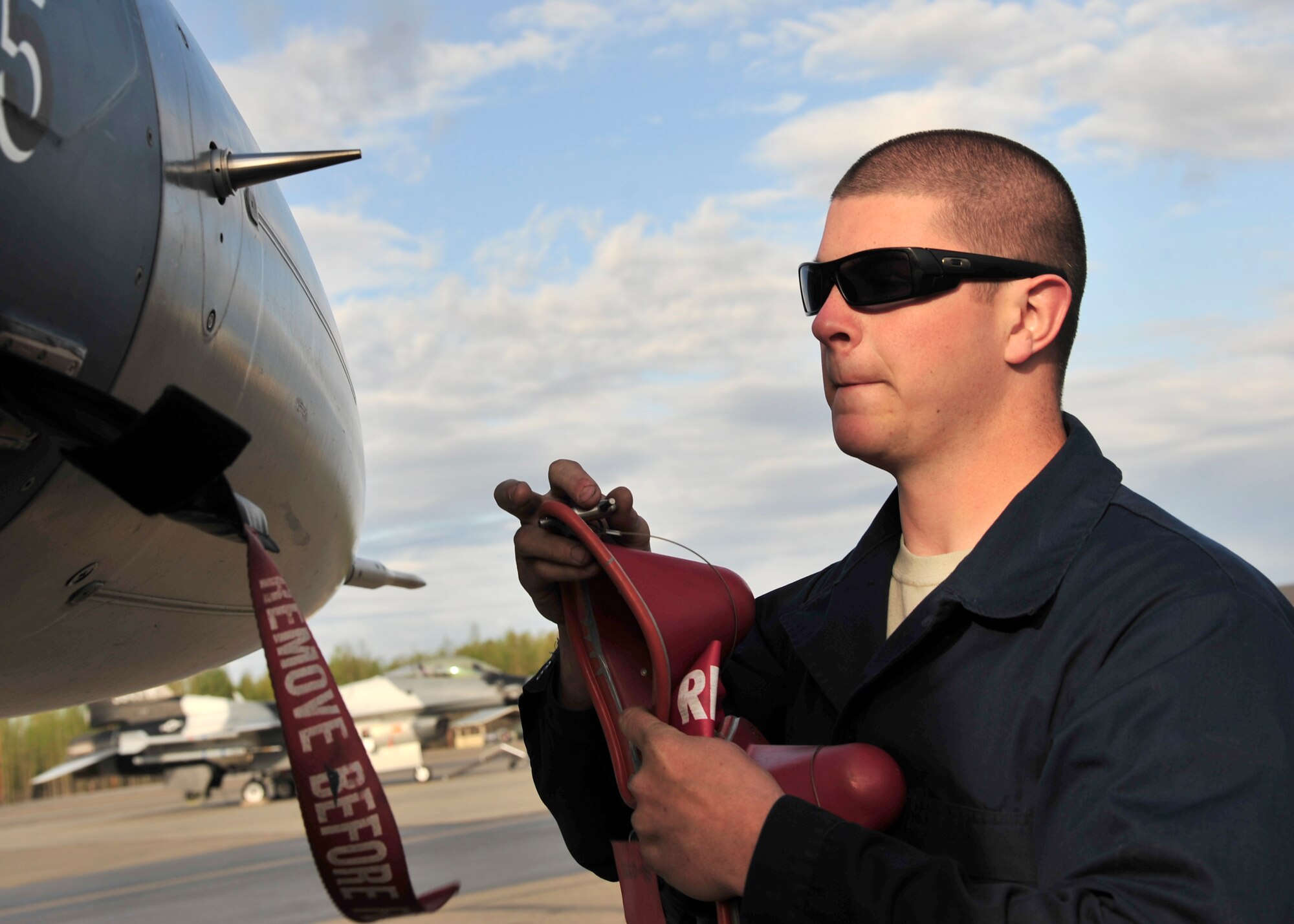 U.S. Air Force Airman 1st Class Kyle Lanning, 354th Aircraft Maintenance Squadron crew chief, removes covers from an F-16 Fighting Falcon May 16, 2014, Eielson Air Force Base, Alaska. After all the covers are removed, Lanning prepares the aircraft for the pilot’s pre-flight inspection. (U.S. Air Force photo by Senior Airman Ashley Nicole Taylor/Released)