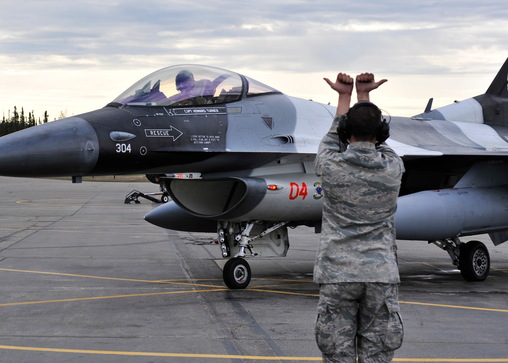 U.S. Air Force Senior Airman Andrew Stachniak, 354th Aircraft Maintenance Squadron crew chief, directs Brig. Gen. Mark Kelly, 354th Fighter Wing commander, May 16, 2014, Eielson Air Force Base, Alaska. Kelly flew the F-16 Fighting Falcon during RED FLAG-Alaska 14-1. (U.S. Air Force photo by Senior Airman Ashley Nicole Taylor/Released) 