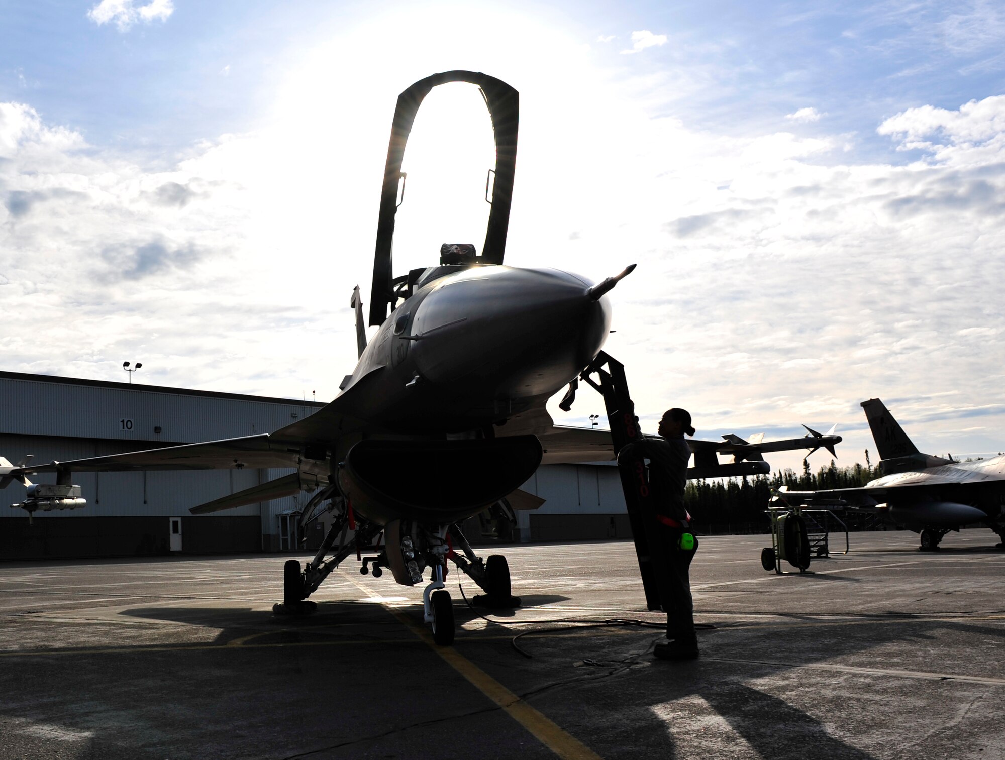U.S. Air Force Airman 1st Class Desirae Perkins, 354th Aircraft Maintenance Squadron crew chief, attaches a step ladder to an F-16 Fighting Falcon May 16, 2014, Eielson Air Force Base, Alaska. Perkins prepared the aircraft so a pilot from the 18th Aggressor Squadron could fly safely. (U.S. Air Force photo by Senior Airman Ashley Nicole Taylor/Released)