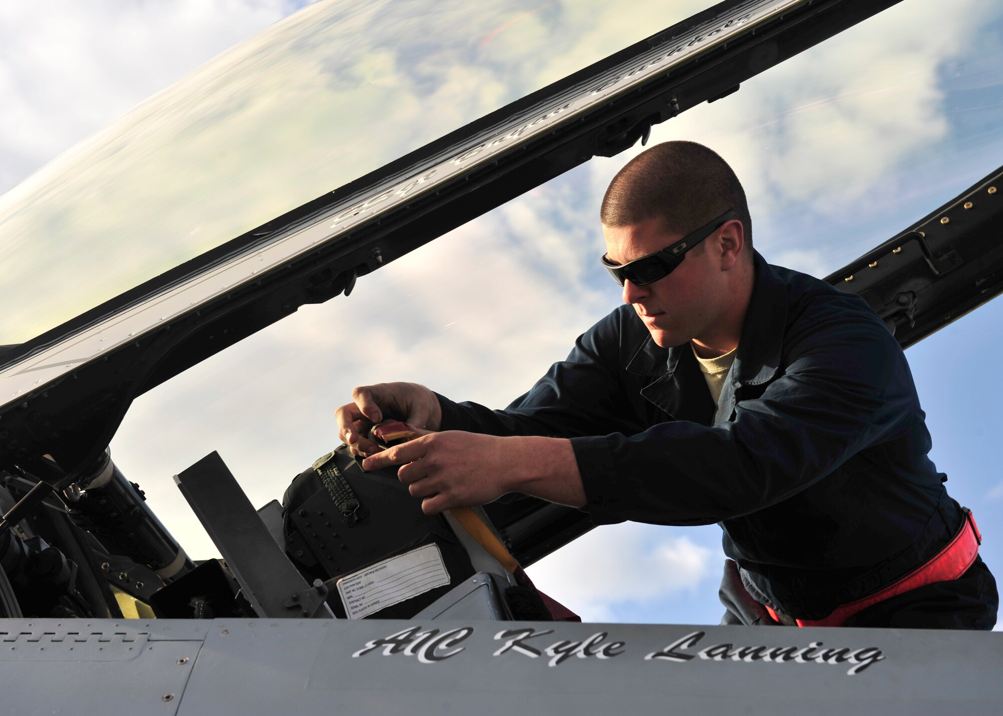 U.S. Air Force Airman 1st Class Kyle Lanning, 354th Aircraft Maintenance Squadron crew chief, removes a cover from the cockpit of an F-16 Fighting Falcon May 16, 2014, Eielson Air Force Base, Alaska. After all the covers are removed, Lanning prepares the jet for a pre-flight inspection. (U.S. Air Force photo by Senior Airman Ashley Nicole Taylor/Released)