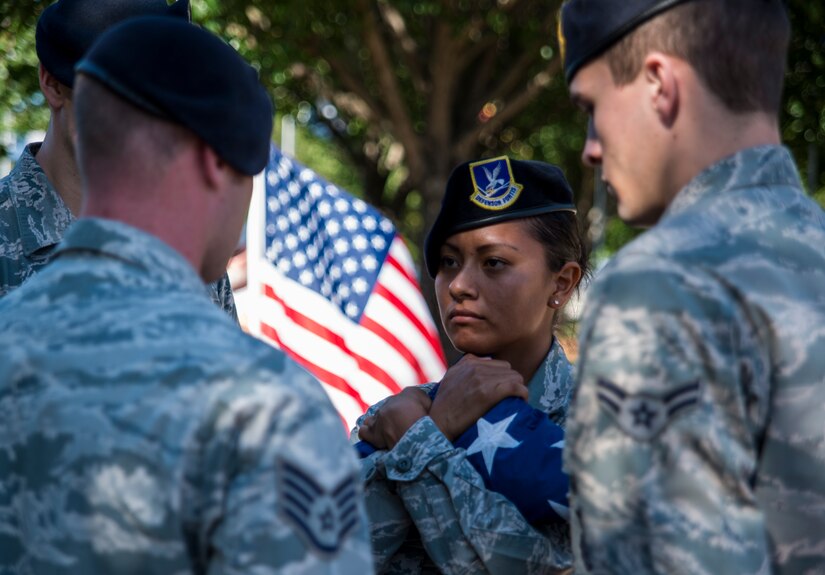 Staff Sgt. Edith Wilkinson, 628th Security Forces Squadron member, receives the flag during a retreat ceremony May 16, 2014, on Joint Base Charleston, S.C. The 628th SFS held different events and activities to commemorate National Police Week from May 11 to 17. (U.S. Air Force photo/ Airman 1st Class Clayton Cupit)
