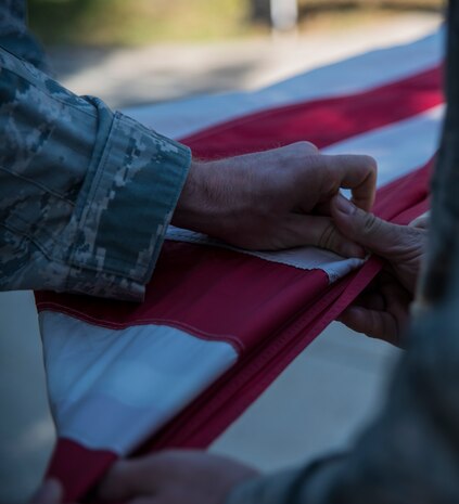 Members of the 628th Security Forces Squadron participate in folding the flag during a retreat ceremony May 16, 2014, on Joint Base Charleston, S.C. The 628th SFS held different events and activities to commemorate National Police Week from May 11 to 17. (U.S. Air Force photo/ Airman 1st Class Clayton Cupit)