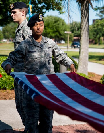 Staff Sgt. Edith Wilkinson, 628th Security Forces Squadron member, participates in folding the flag during a retreat ceremony May 16, 2014, on Joint Base Charleston, S.C. The 628th SFS held different events and activities to commemorate National Police Week from May 11 to 17. (U.S. Air Force photo/ Airman 1st Class Clayton Cupit)