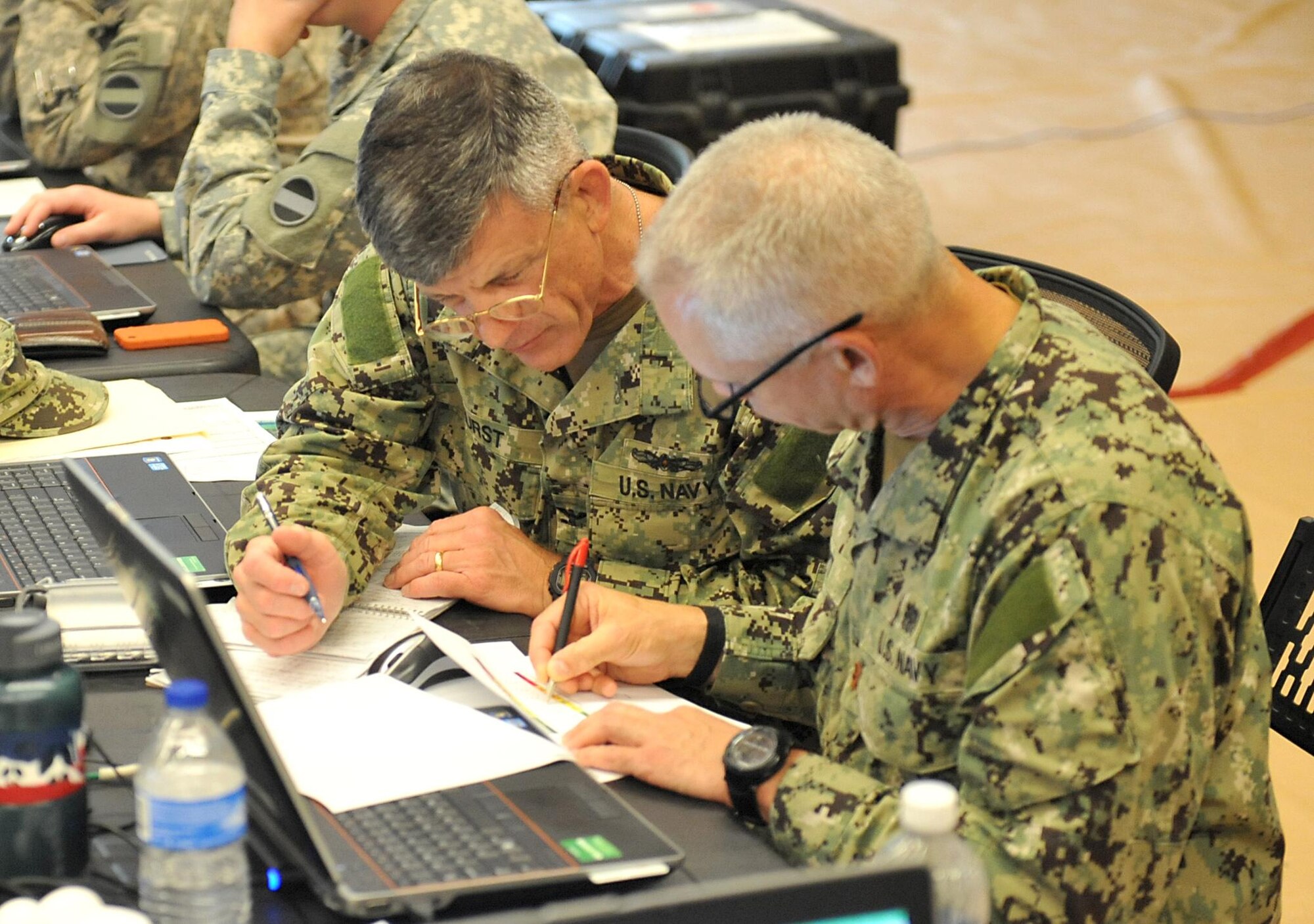 U.S. Navy Capt. William Hurst, command surgeon, Joint Task Force Civil Support, and U.S. Navy Lt. Cmdr. Craig Knott, medical operations chief, JTF-CS, discuss the radiation dosimetry summary during Sudden Response 2014 at Camp Dawson, W.Va, May 14, 2014. Sudden Response 2014 tests and validates the unit's movement of equipment and personnel during the initial phases of a simulated man-made or natural disaster. JTF-CS anticipates, plans and prepares for chemical, biological, radiological and nuclear defense support to civil authorities response operations. (DOD photo by U.S. Navy Petty Officer 1st Class Brian Dietrick/Released)