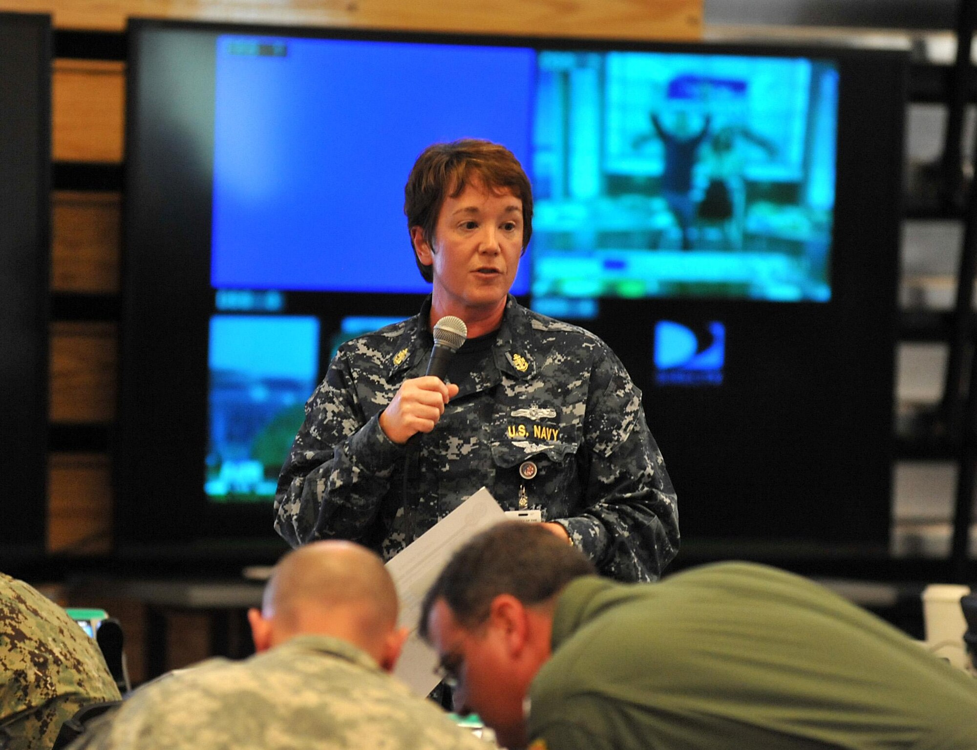 U.S. Navy Chief Petty Officer Kristine Ingle, Aerographer's Mate, Joint Intelligence Fusion Center, briefs weather conditions and the impact it has on response operations at a shift change during Sudden Response 2014 at Camp Dawson, W.Va, May 13, 2014. Shift change briefs are structured to cover the current situation and any changes to the plan or commanders intent. Sudden Response 2014 tests and validates the unit's movement of equipment and personnel during the initial phases of a simulated man-made or natural disaster. (DOD photo by U.S. Navy Petty Officer 1st Class Brian Dietrick/Released)