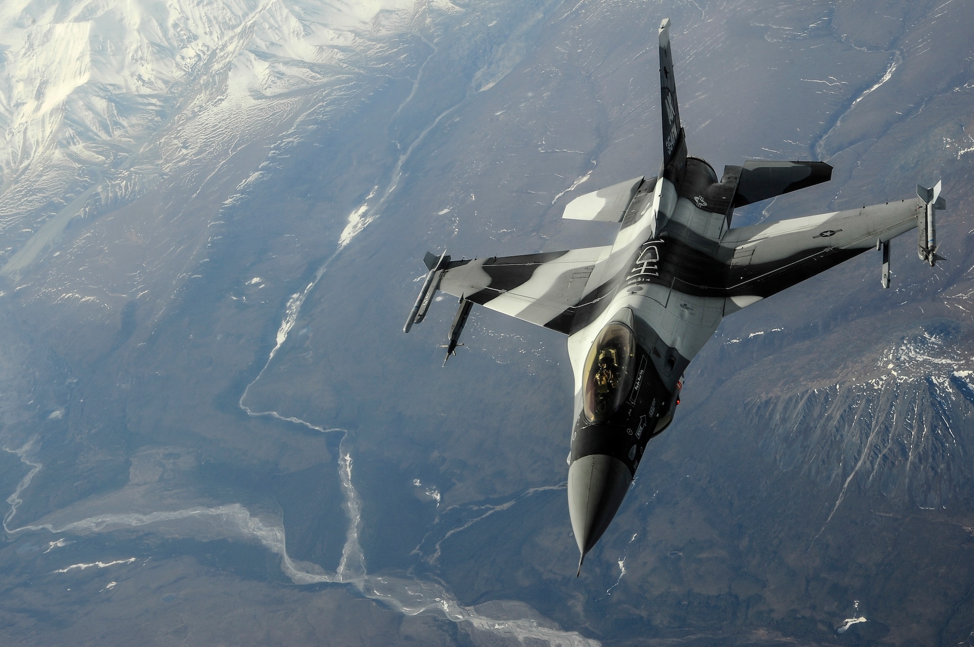 A U.S. Air Force F-16 Fighting Falcon pilot from the 18th Aggressor Squadron, Eielson Air Force Base, Alaska, breaks away after being refueled by a KC-135 Stratotanker over the Joint Pacific Alaska Range Complex during RED FLAG-Alaska 14-1 May 15, 2014. RF-A is a Pacific Air Forces-sponsored field training exercise designed to increase wartime capabilities in a simulated combat environment. (U.S. Air Force photo by Senior Airman Zachary Perras/Released)