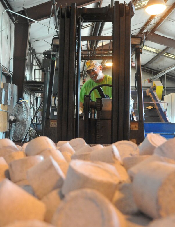 Mark Davis, 509th Force Support Squadron recycling center supervisor, lifts a bin of paper briquettes using a forklift at Whiteman Air Force Base, Mo., May 7, 2014. The paper briquette must be put into a shipping container to prepare to be shipped. (U.S. Air Force photo by Airman 1st Class Keenan Berry/Released)