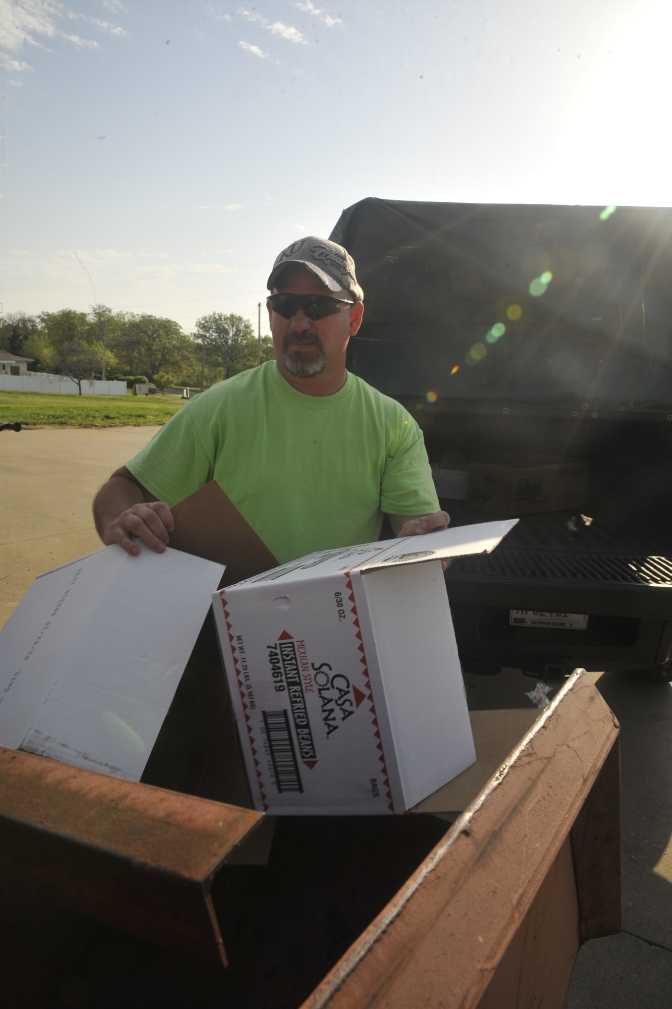 Jeff Willming, 509th Force Support Squadron material examiner and identifier, gathers cardboard from a bin at Whiteman Air Force Base, Mo., May 7, 2014. Recycling center crew members must go around base and collect cardboard from bins and dumpsters in order to condense it and sell it to companies. (U.S. Air Force photo by Airman 1st Class Keenan Berry/Released)