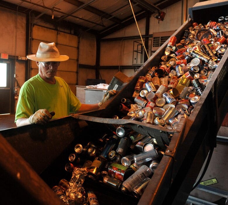 Eric Goewey, 509th Force Support Squadron material examiner and identifier, examines aluminum cans at Whiteman Air Force Base, Mo., May 7, 2014. In order to sell bales of cans to companies, the recycling center crew must ensure all bales are free of unwanted waste. (U.S. Air Force photo by Airman 1st Class Keenan Berry/Released)