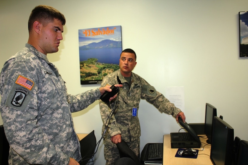 (Left) Spc. Cory Cantlay, a signal support systems specialist and Chief Warrant Officer Preston Garner, an air planner, both part of the SOUTHCOM Situational Assessment Team, set up communications equipment at the U.S. Embassy in El Salvador as part of FA-HUM 2014 exercise May 9. The SSAT was deployed for the first time for FA-HUM 2014, a humanitarian and disaster relief exercise in San Salvador, El Salvador.  (Photo by U. S. Army Lt. Col. Carol McClelland)