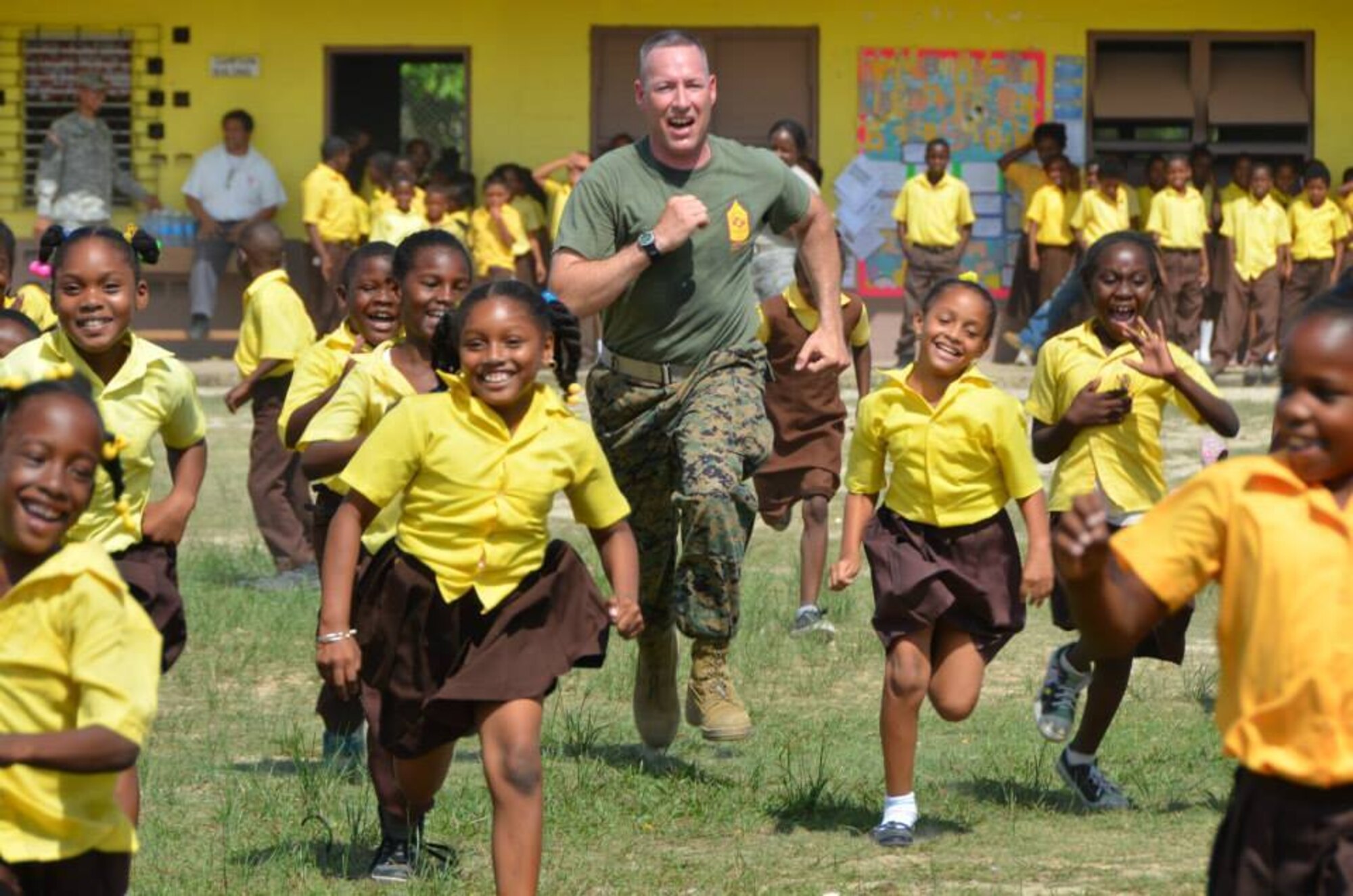 U.S. Marine Corps Gunnery Sgt. Keith Day challenges Hattieville Government School students to a race during a physical fitness lesson he led. Day is deployed in support of the New Horizons training exercise in Belize.