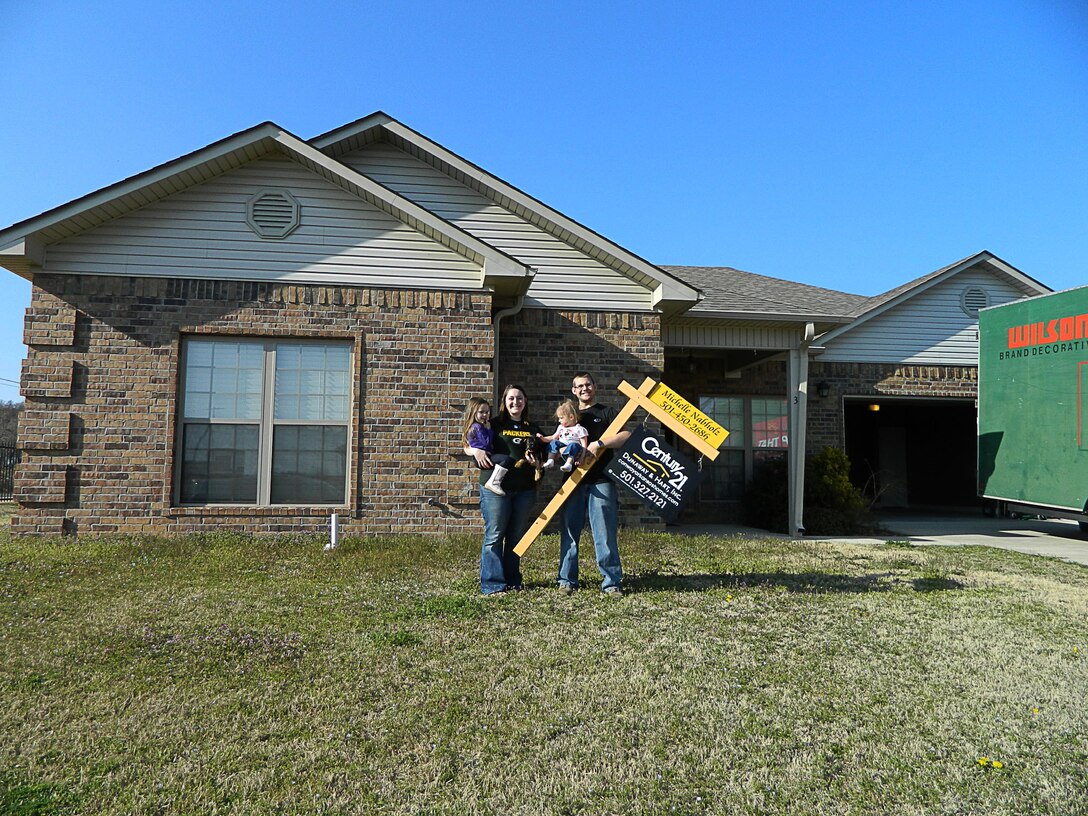 The Baker family in happier times.  Tiffany, Aubri, Adalynn and Senior Airman Drew Baker show off their new home on move-in day several months before an EF4 tornado destroyed the house on April 27, 2014.  The family dog, ‘Batman,’ survived the ordeal and was found unharmed more than a mile from the site. (Photo provided by Senior Airman Drew Baker.)