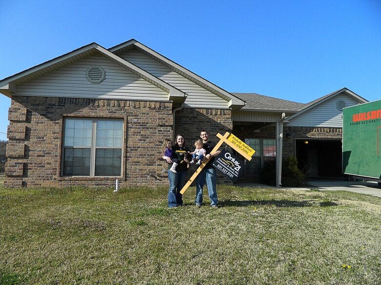 The Baker family in happier times.  Tiffany, Aubri, Adalynn and Senior Airman Drew Baker show off their new home on move-in day several months before an EF4 tornado destroyed the house on April 27, 2014.  The family dog, ‘Batman,’ survived the ordeal and was found unharmed more than a mile from the site. (Photo provided by Senior Airman Drew Baker.)