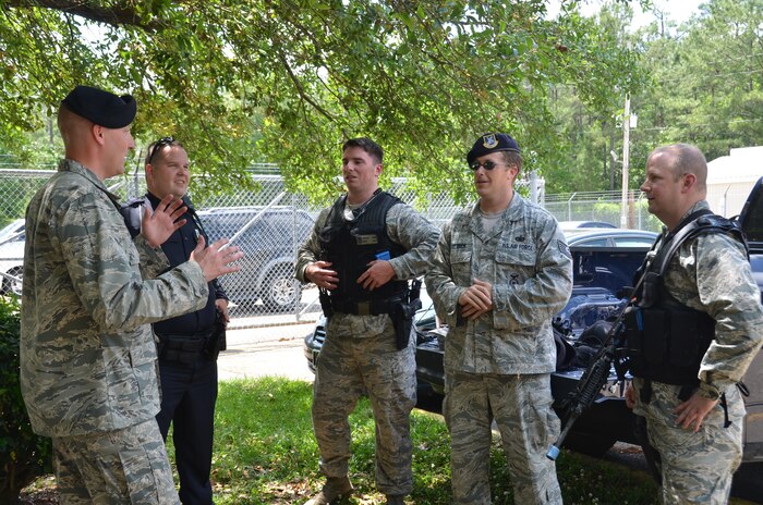 Col. Jeffrey DeVore, Joint Base Charleston commander (right), receives a briefing after his participation in an Active Shooter exercise, May 14, 2014, at Joint Base Charleston – Weapons Station. DeVore was riding along with the 628th SFS as part of a program designed to give base leaders a taste of what Airmen and Sailors do at their job centers every day. (U.S. Air Force photo/Eric Sesit)