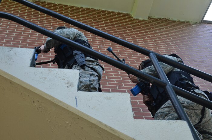 Col. Jeffrey DeVore, Joint Base Charleston commander (right), prepares to enter a building as part of an Active-Shooter exercise May 14, 2014 on Joint Base Charleston – Weapons Station. DeVore was riding along with the 628th SFS as part of a program designed to give base leaders a taste of what Airmen and Sailors do at their job centers every day. (U.S. Air Force photo/Eric Sesit)