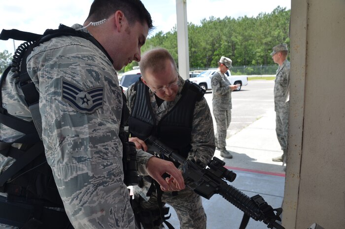 Staff Sgt. Patrick Poss, 628th Security Forces Squadron patrolman, assists Col. Jeffrey DeVore, Joint Base Charleston commander, as the colonel clears his weapon before beginning his “shift,” May 14, 2014, on JB Charleston – Weapons Station. DeVore was riding along with the 628th SFS as part of a program designed to give base leaders a taste of what Airmen and Sailors do at their job centers every day. (U.S. Air Force photo/Eric Sesit)