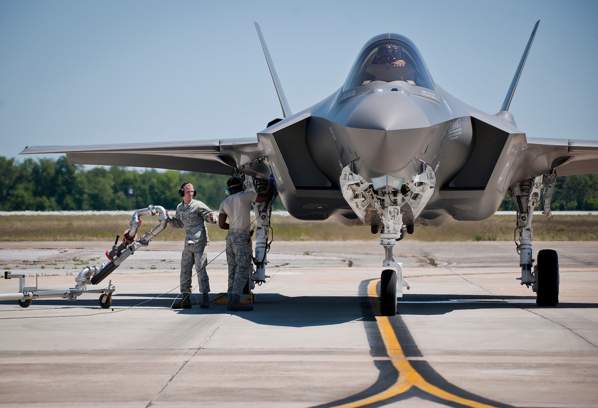 Senior Airman Jordan Shope, 96th Fuels Flight, brings out the refueling arm for Staff Sgt. Mark Freeman, 33rd Aircraft Maintenance Squadron, during an F-35A Lightning II hot pit session May 6 at Eglin Air Force Base, Fla.  The fuels flight facilitates the four hot pit stations on the 33rd Fighter Wing flightline used by Air Force, Marine Corps and Navy F-35 aircraft. The 131 Airmen and civilians of the fuels flight fall under the 96th Logistics Readiness Squadron and were recently named best fuels flight in Air Force Materiel Command.  (U.S. Air Force photo/Samuel King Jr.)