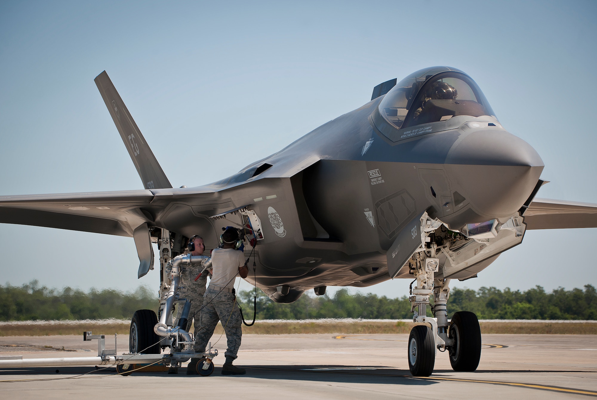 Senior Airman Jordan Shope, 96th Fuels Flight, and Staff Sgt. Mark Freeman, 33rd Aircraft Maintenance Squadron, attach the refueling arm to an F-35A Lightning II during a hot pit session May 6 at Eglin Air Force Base, Fla.  The fuels flight facilitates the four hot pit stations on the 33rd Fighter Wing flightline used by Air Force, Marine Corps and Navy F-35 aircraft. (U.S. Air Force photo/Samuel King Jr.)  