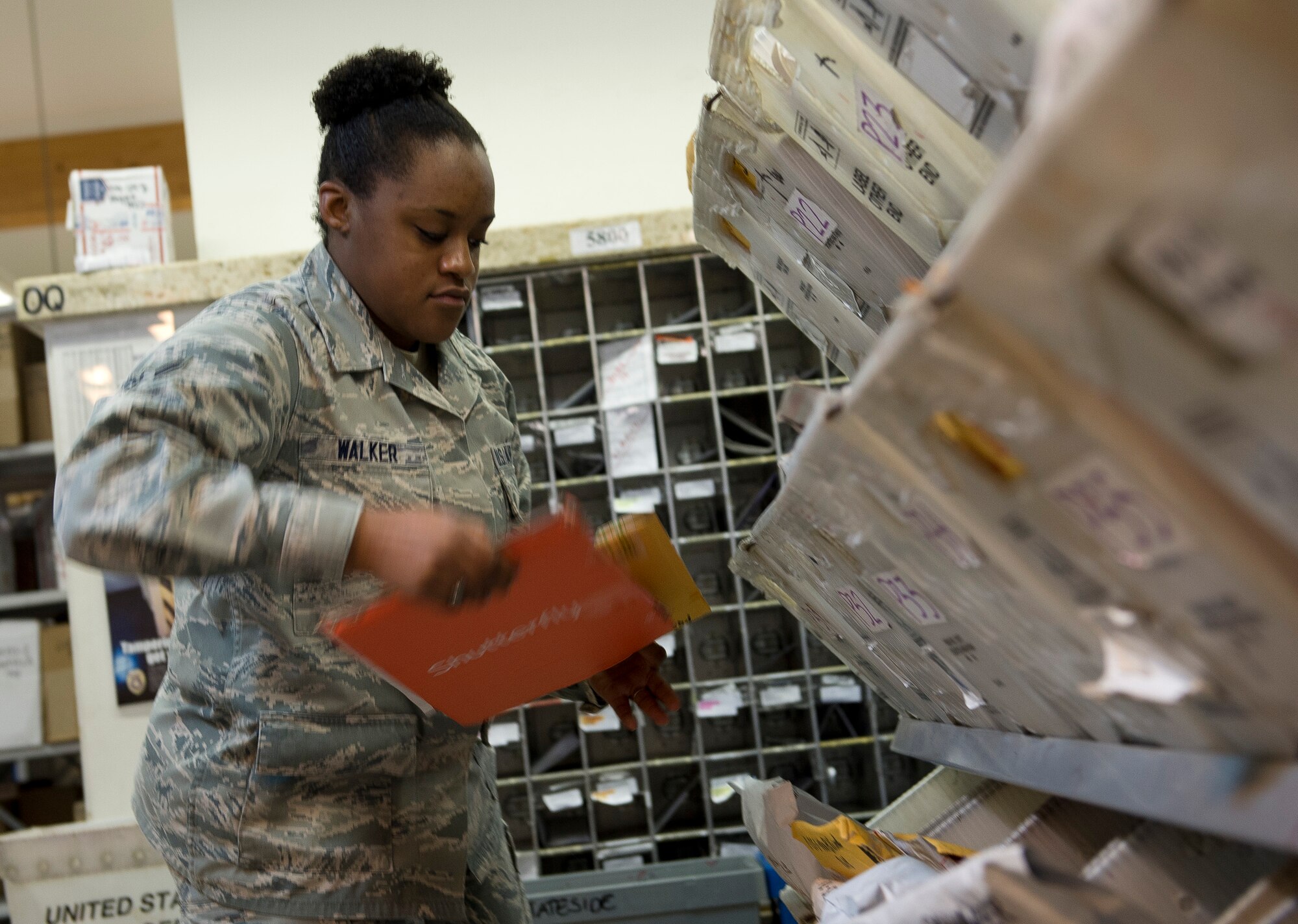 U.S. Air Force Airman 1st Class Kathryn Walker, a 52nd Communications Squadron military postal clerk from Houston, retrieves mail for customers at Spangdahlem Air Base, Germany, May 16, 2014. The post office provides a full spectrum of postal services to more than 13,000 base members. (U.S. Air Force photo by Staff Sgt. Chad Warren/Released)