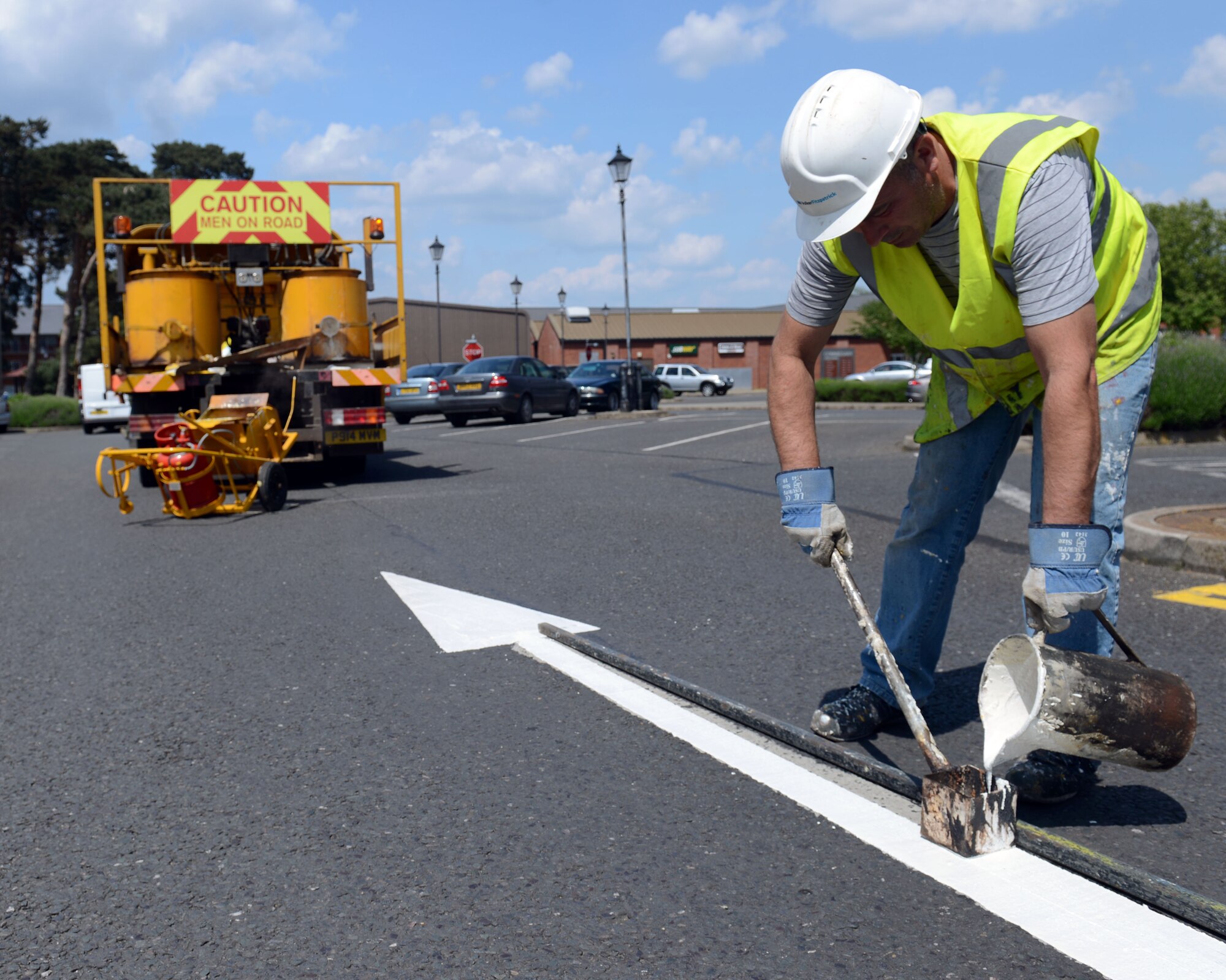 Contractor Richard Good repaints an arrow May 19, 2014, on RAF Mildenhall, England. The markings in several parking lots around base were revitalized to increase their visibility for drivers on base. (U.S. Air Force photo by Airman 1st Class Preston Webb/Released)