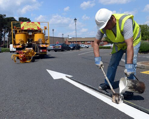 Contractor Richard Good repaints an arrow May 19, 2014, on RAF Mildenhall, England. The markings in several parking lots around base were revitalized to increase their visibility for drivers on base. (U.S. Air Force photo by Airman 1st Class Preston Webb/Released)