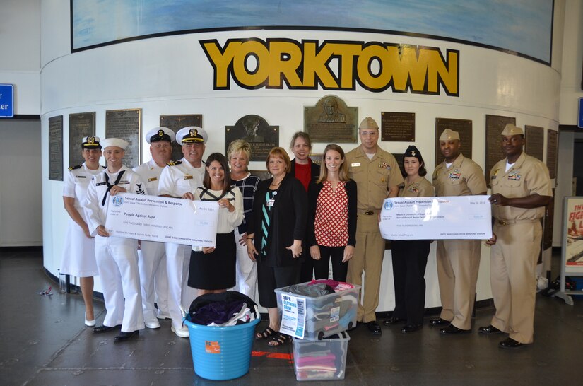 Sailors from Joint Base Charleston – Weapons Station, present the Medical University of South Carolina and People Against Rape, monetary donations and clothing, onboard the USS Yorktown in Patriot’s Point, Mt. Pleasant, S.C. The donations were collected during Sexual Assault Awareness Month this past April.  (Left to right) Lt. jg. Amy Ellison, Naval Nuclear Power Training Command, Petty Officer 1st Class Chris Bryant, NNPTC, Master Chief Petty Officer Joseph Gardner, Naval Support Activity command master chief, Capt. Timothy Sparks, Joint Base Charleston deputy commander, Tiffany Mizzell, JB Charleston – Weapons Station Sexual Assault Response Coordinator, Janet Ward, Medical University of South Carolina Sexual Assault Nurse Examiner, Nancy Hall, MUSC SANE, Stacey Tunstill, People Against Rape executive director, Alex Jeffery, People Against Rape volunteer coordinator, Master Chief Petty Officer Donald Ziegler, Nuclear Power Training Unit Charleston command master chief, Petty Officer 1st Class Amanda Smith, NPTU, Senior Chief Petty Officer Rodney Colbourne, NPTU, and Chief Petty Officer Jermaine Glover, NPTU.