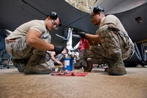 Senior Airman Carlos Carcamo, left, 108th Wing Maintenance Squadron, and Staff Sgt. Ivan R. Martinez, 108th Wing Aircraft Maintenance Squadron, both with the New Jersey Air National Guard, clean axle parts during the inspection of a KC-135R Stratotanker wing landing gear axle May 17, 2014, at Joint Base McGuire-Dix-Lakehurst, N.J. (U.S. Air National Guard photo by Master Sgt. Mark C. Olsen/Released)