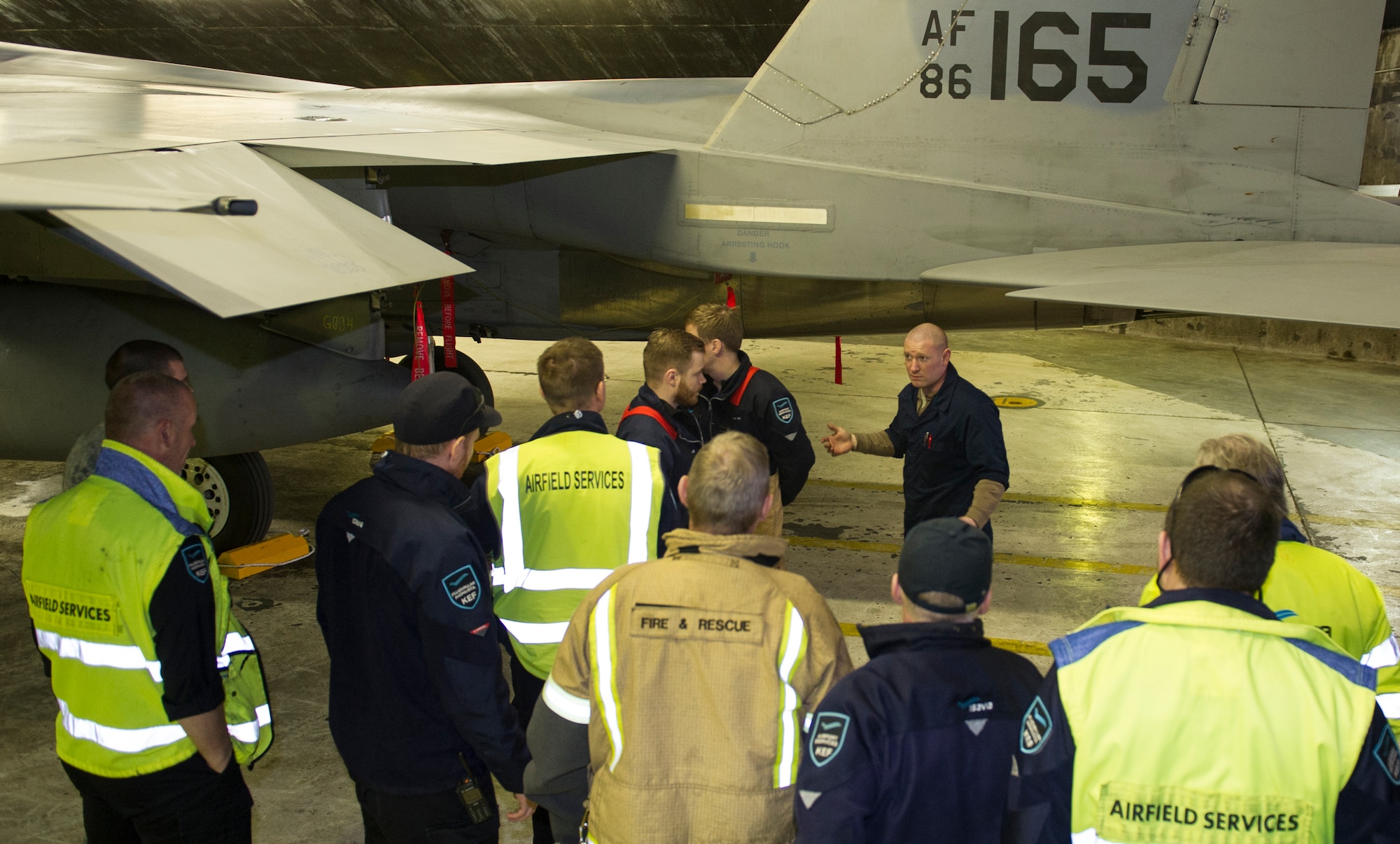 KEFLAVIK, Iceland -- Staff Sgt. Caleb Schauer, 48th Expeditionary Air Group dedicated crew chief, speaks with airfield service members during emergency response training at Keflavik International Airport, May 16, 2014. Airfield services were trained on pilot extraction procedures for the F-15C Eagle so they could help respond in the event of an emergency while the aircraft is deployed for Icelandic Air Policing. (U.S. Air Force photo/Tech. Sgt. Benjamin Wilson)(Released)