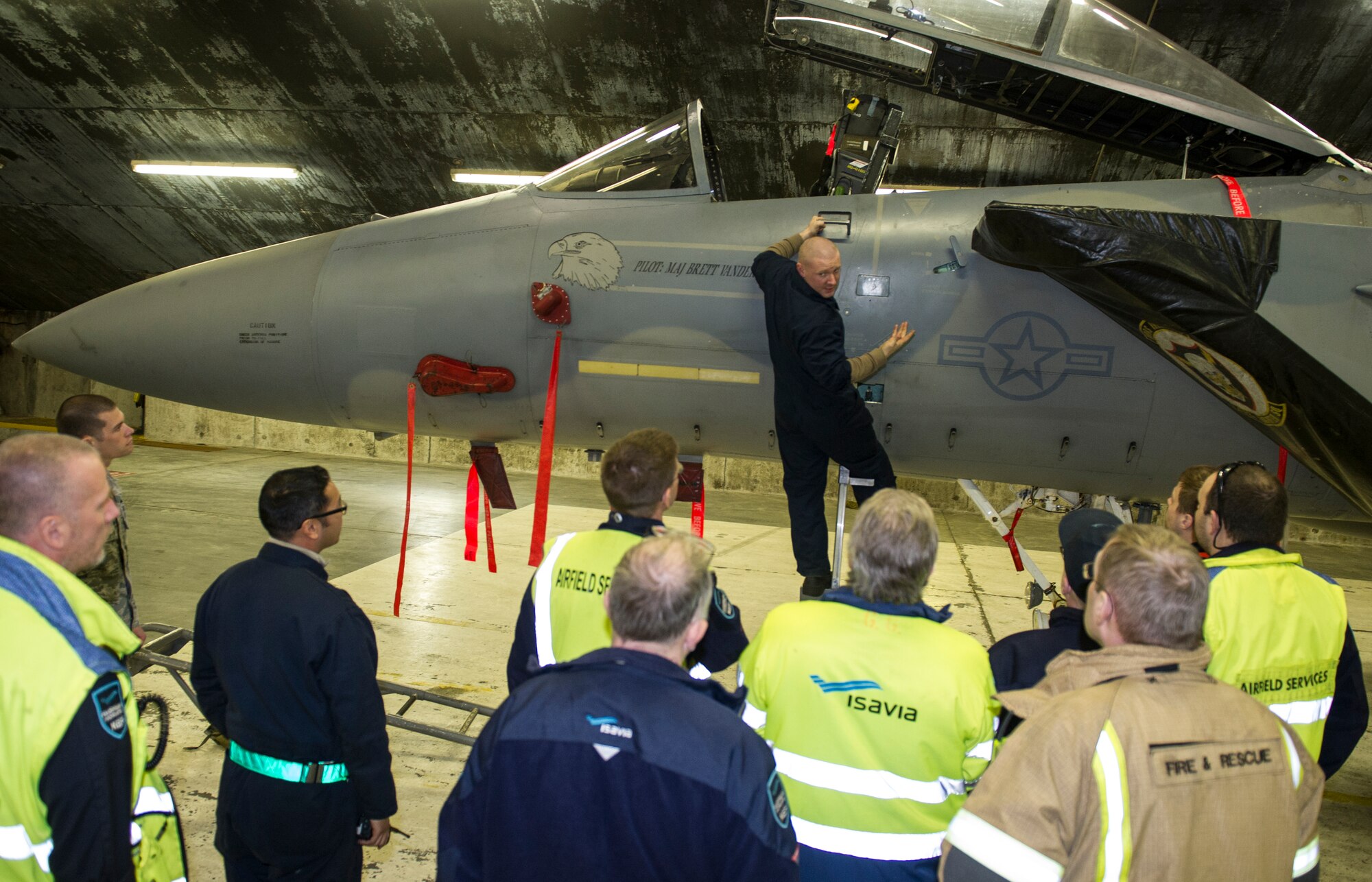 KEFLAVIK, Iceland -- Staff Sgt. Caleb Schauer, 48th Expeditionary Air Group dedicated crew chief, teaches airfield service members where the emergency canopy release for the F-15C Eagle is during emergency response training at Keflavik International Airport, May 16, 2014. Airfield services were trained on pilot extraction procedures so they could help respond in the event of an emergency while the aircraft is deployed for Icelandic Air Policing. (U.S. Air Force photo/Tech. Sgt. Benjamin Wilson)(Released)