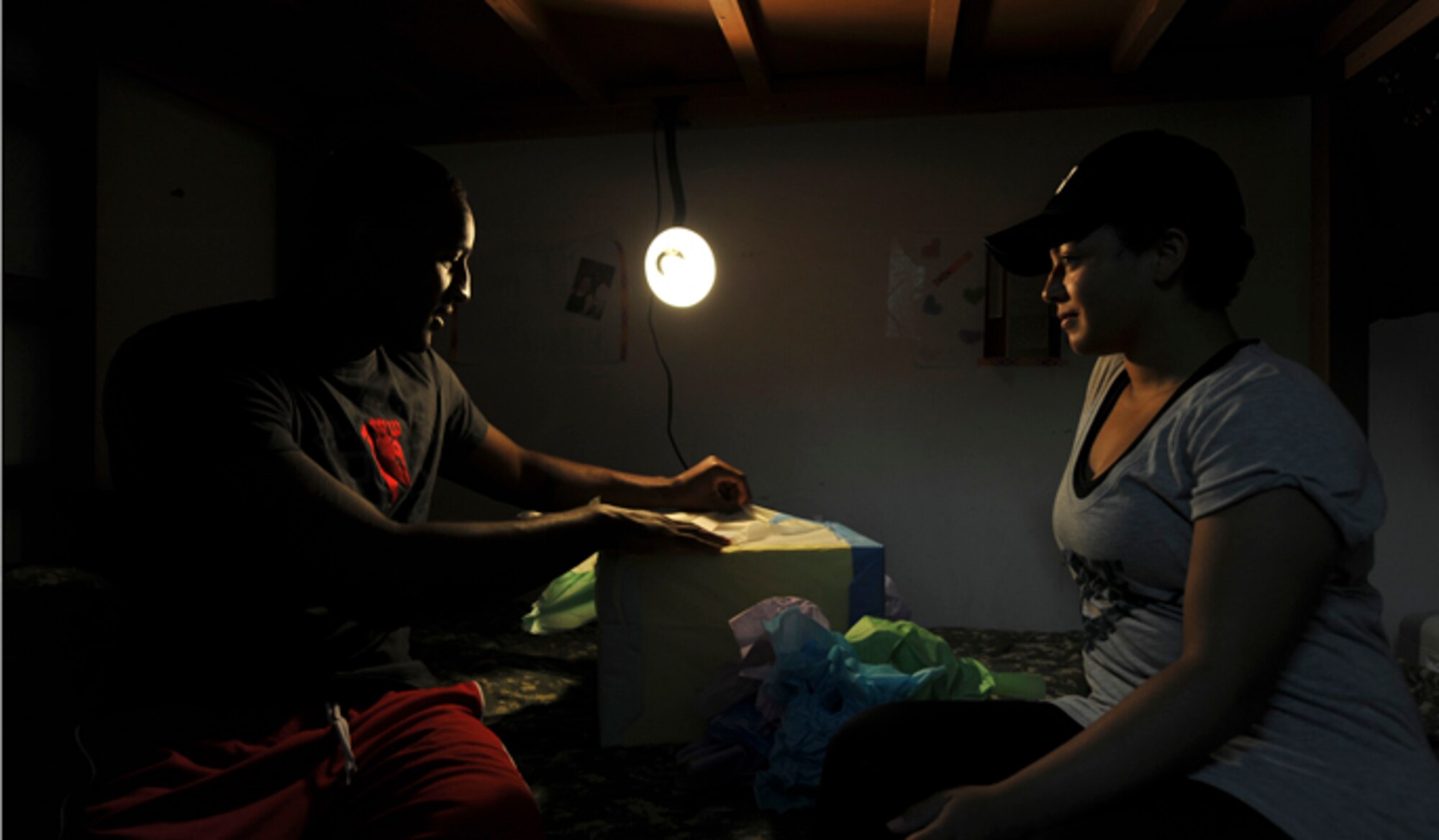 Senior Airman Shawn Brock, a 380th Expeditionary Civil Engineer Squadron firefighter, opens an anniversary gift from his wife, Hillary, May 15, 2014, at an undisclosed location in Southwest Asia. The Brocks celebrated their first wedding anniversary while deployed. 