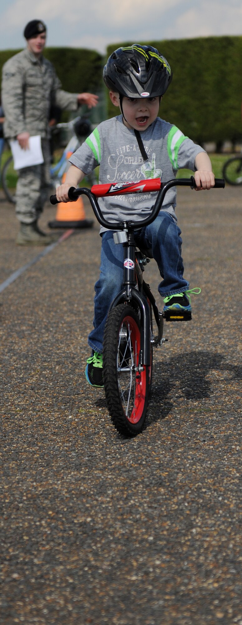 A military child practices safe bicycle riding habits during a bike safety rodeo at RAF Alconbury, United Kingdom, May 14, 2014. During the rodeo, children were taught how to properly wear their bike helmets. (U.S. Air Force photo by Staff Sgt. Jarad A. Denton/Released)