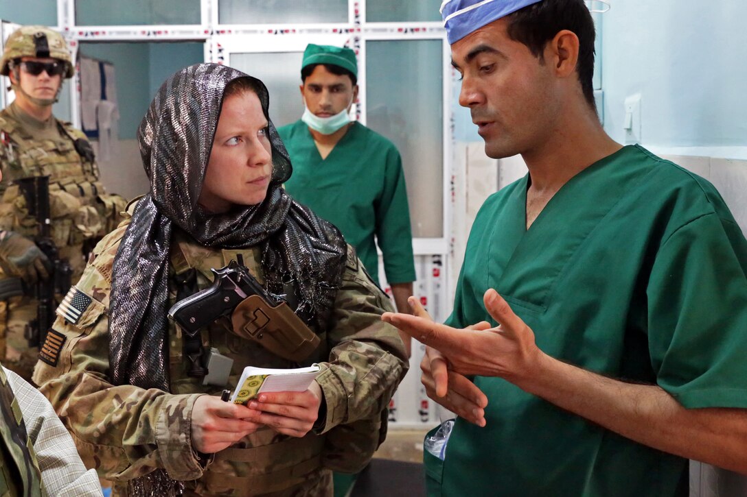 U.S. Navy Lt. j.g. Laura Cook, left, talks with Ahmad Jawid Ghafoori, hospital anesthesiologist, during a meeting at Farah City Hospital in Afghanistan's Farah province, March 26, 2013. Cook, a physician assistant, is assigned to Provincial Reconstruction Team Farah. 
