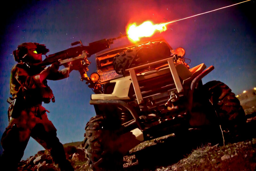 A U.S. Marine assigned to a Special Operations team fires an M240B machine gun during night training in Helmand province, Afghanistan, March 28, 2013. Team members are deployed in Helmand province to train and mentor Afghan security forces.  
