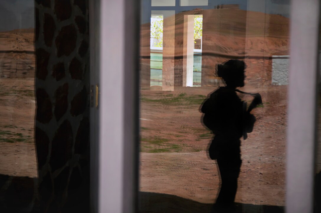 A coalition force member maintains security during a patrol with Afghan national police and Afghan national army special forces to escort a district governor in Helmand province, Afghanistan, March 17, 2013.  
