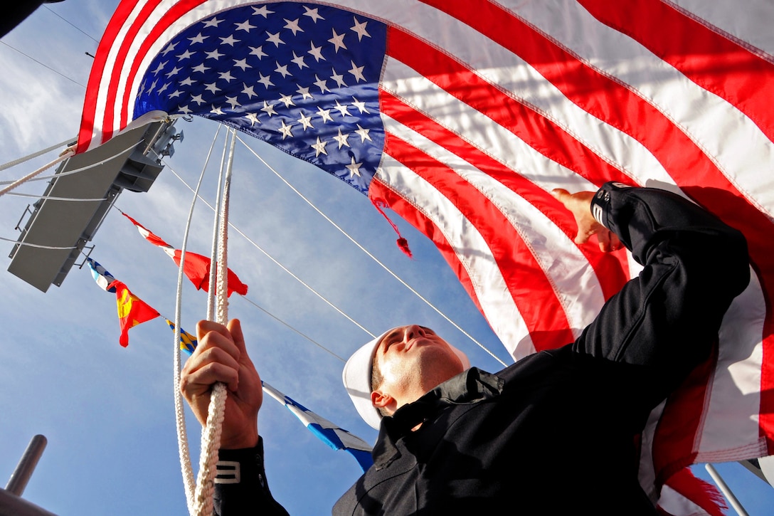 Navy Seaman Vincent Peters shifts colors aboard the aircraft carrier USS Ronald Reagan as it completes its homeport change from Bremerton, Wash., to San Diego, March 21, 2013.  
