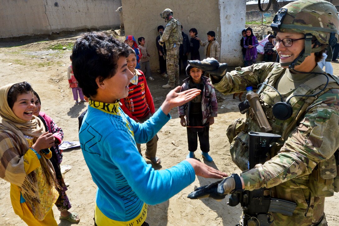 U.S. Air Force Staff Sgt. Elizabeth Rosato meets with Afghan school children outside of Bagram Airfield, Afghanistan, March 11, 2013. The Reaper team conducts patrols near the airfield to counter improvised explosive devices and indirect fire attacks as well as to engage Afghan support in protecting the base. Rosato is assigned to the 755th Expeditionary Security Forces Squadron Reaper Team 1.  
