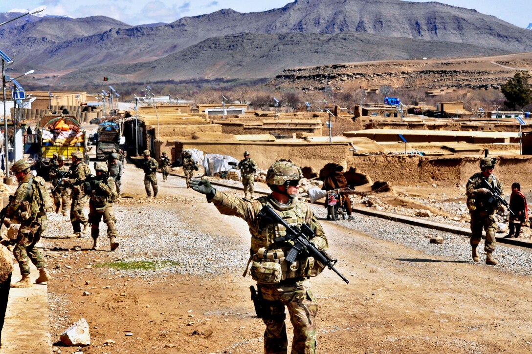 U.S Army Sgt. 1st Class Freddy Bloom directs a patrol through the city of Chorah, Afghanistan, Feb. 23, 2013. The team was en route to Forward Operating Base Mirwais after mentoring local police officers at Afghan police district headquarters. Bloom is a member of a Security Force Assistance Team.  
