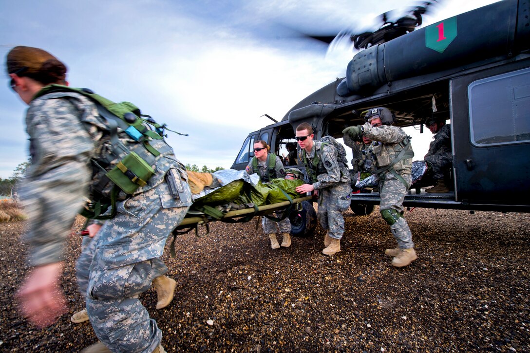 Army medical personnel offload a simulated injured soldier from a HH-60L Black Hawk helicopter during aeromedical evacuation training on Fort Polk, La., Feb. 23, 2013.  
