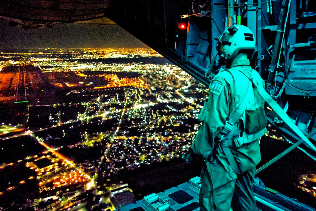 U.S. Air Force Staff Sgt. Nickolas Alarcon observes a drop zone from the rear of a C-130 Hercules aircraft after deploying a light payload above Yokota Air Base, Japan, Feb. 21, 2013. Alarcon, a loadmaster, is assigned to the 36th Airlift Squadron. The C-130 aircrews demonstrated their airlift capabilities during a readiness week.  
