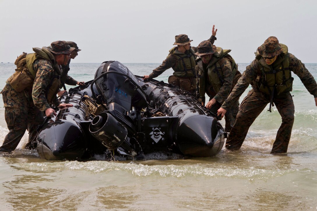 U.S. Marines and sailors drag a boat into position after coming ashore during a bilateral boat raid as a part of exercise Cobra Gold 2013 in Hat Yao, None, Thailand, Feb. 15, 2013.  
