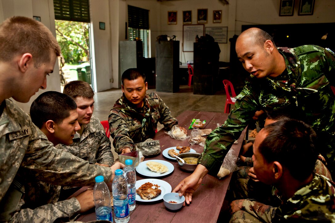 U.S. and Thai soldiers share a meal after learning various Thai infantry tactics during Exercise Cobra Gold 2013 on Camp Akatosrot in Phitsanulok province,Thailand, Feb. 15, 2013. As the largest multinational exercise in the Asia-Pacific region, Cobra Gold provides an opportunity for the United States, Thailand, Singapore, Japan, South Korea, Indonesia and Malaysia to maintain relationships and enhance interoperability. 
