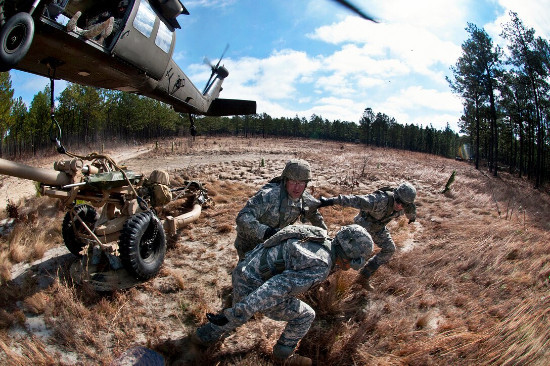 Paratroopers move out of the way after they hook an M119A2 105mm howitzer to a UH-60 Black Hawk helicopter during air assault training on Fort Bragg, N.C., Feb. 8, 2013. The paratroopers are assigned to the 82nd Airborne Division’s 3rd Battalion, 319th Airborne Field Artillery Regiment, 1st Brigade Combat Team.  
