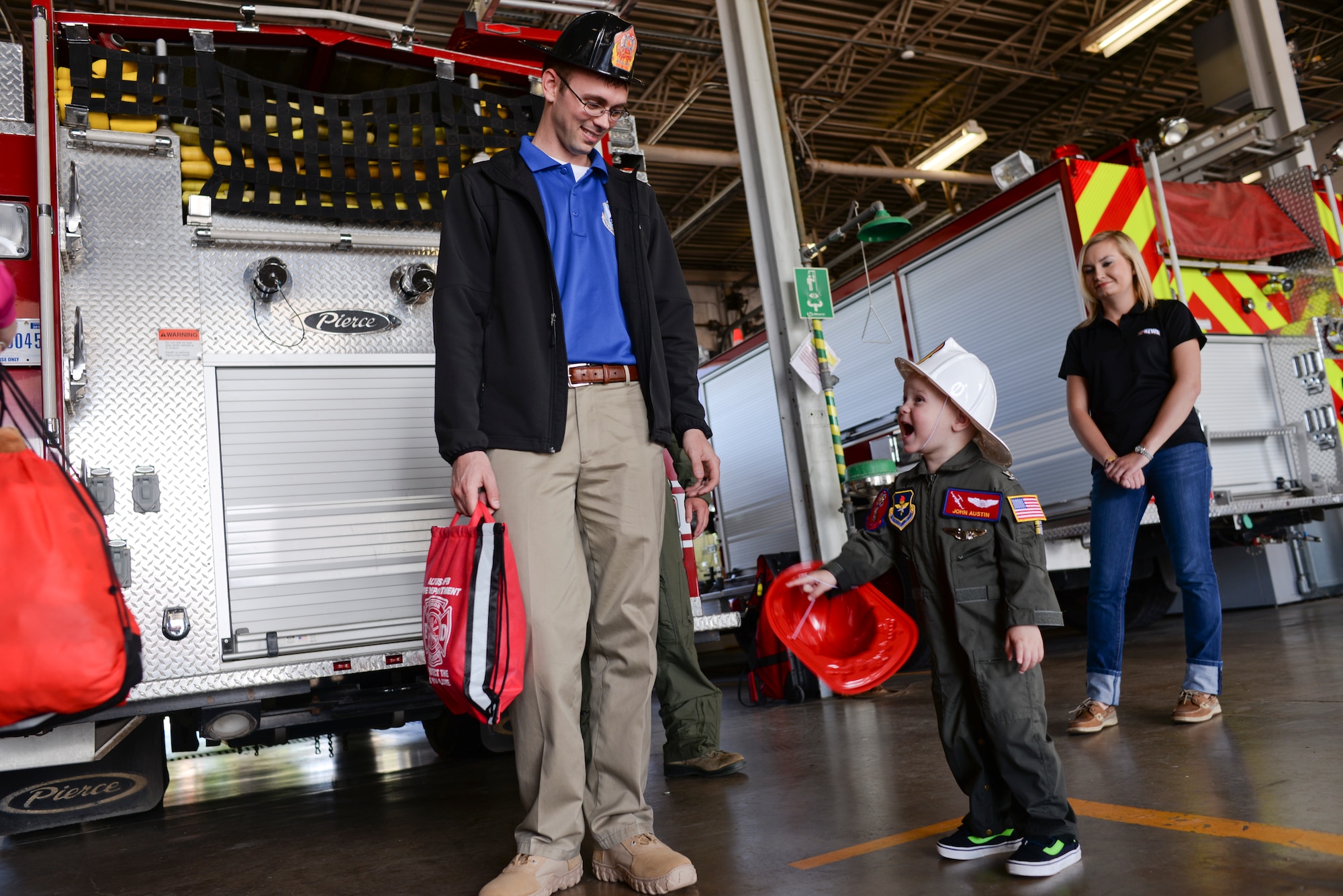 Two-year-old John Austin laughs with his father, Jason, after touring the base fire department May 15, 2014, at Altus Air Force Base, Oklahoma. The Austin family is stationed at Tinker Air Force Base, and had the opportunity to visit Altus AFB as part of the Altus Pilot for a Day program. (U.S. Air Force photo/Staff Sgt. Nathanael Callon) 