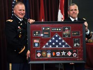 Huntsville Center Commander Col. Robert Ruch, left, presents Huntsville Center Deputy Commander Lt. Col. William Burruss with a shadow box highlighting Burruss’ 25-year Army career during Burruss’ retirement ceremony at the Center May 19.  Burruss had been Huntsville Center deputy commander since July 2011.