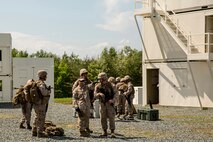 2nd Lt. James Blake (left center), a Litchfield, Conn., native and the evacuation control center officer in charge instructs ECC team members on checkpoint set-up procedures to streamline the process of relocating evacuees aboard Marine Corps Base Quantico, Va., May 13, 2014. The noncombatant evacuation operation (NEO) exercise was used to meet a specific mission essential training requirement for their upcoming deployment. (U.S. Marine Corps photo by Cpl. Shawn Valosin)