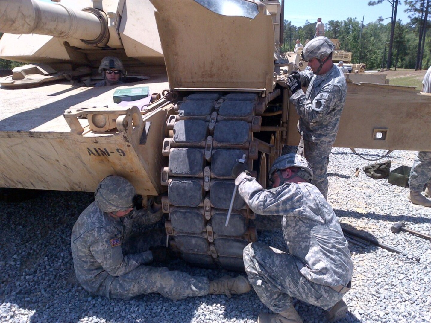 Members of the Pennsylvania National Guard perform repairs on an Abrams tank track as part of qualifying round of the Sullivan Cup armor competition at Fort Benning, Georgia, May 7, 2014. 
